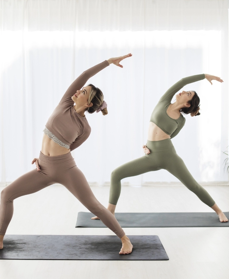 dwie kobiety ćwiczące joge